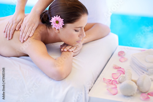 Wellness, massage and woman at spa pool with flower for health, relax and luxury holistic treatment. Self care, peace and girl on table with masseuse for body therapy, sleep and calm hotel service