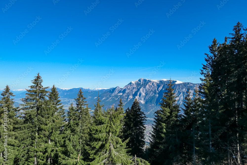 Panoramic view of majestic mountain peak Dobratsch seen from idyllic forestin on Dreilaendereck in untamed Karawanks, Carinthia, Austria. Alpine landscape in spring in Austrian Alps. Wanderlust