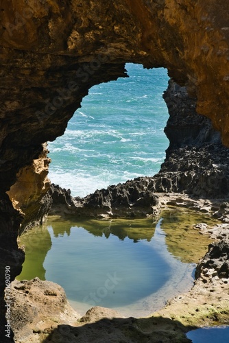 Stunning view of an opening in a cave on the beach, leading to the transition between land and sea