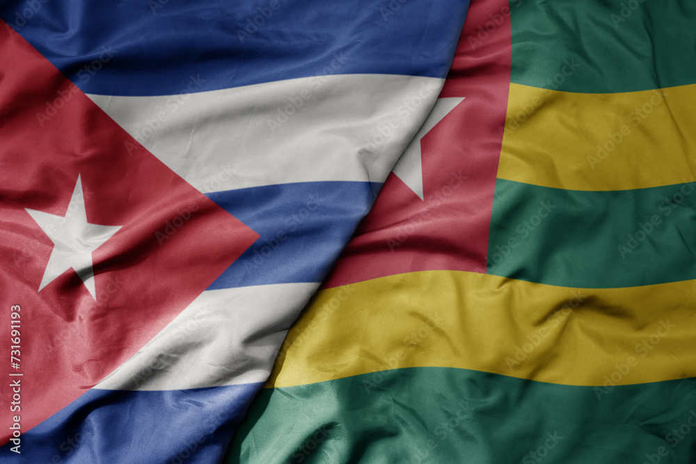 big waving national colorful flag of togo and national flag of cuba .