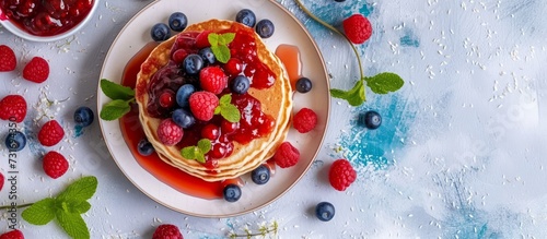 Healthy pancake topping consisting of whole grains, jam, and various berries.