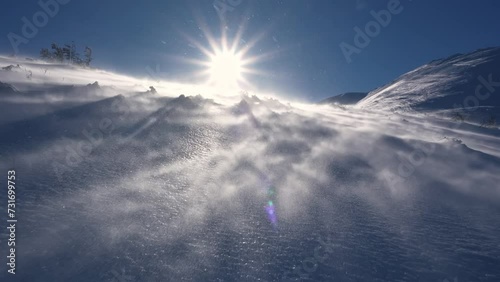 Panorama of frozen winter alps mountains with snow blown by strong wind in windy nature, low angle view photo