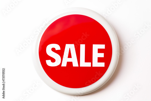 a vibrant red button with the word sale isolated on a bright white background signifying a promotional event