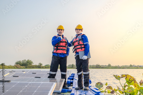 Canvas-taulu Skilled technicians supervise operations at a floating solar farm at sunset