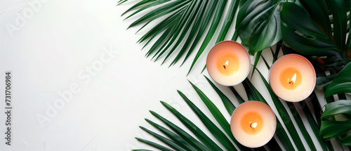 Top view image of candles and palm leaves for spa concept with empty space for text. Calmness, wellbeing and selfcare.