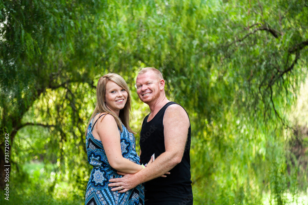 Portrait of a happy man and woman standing together in greenery Portrait of a happy man and woman standing together in greenery