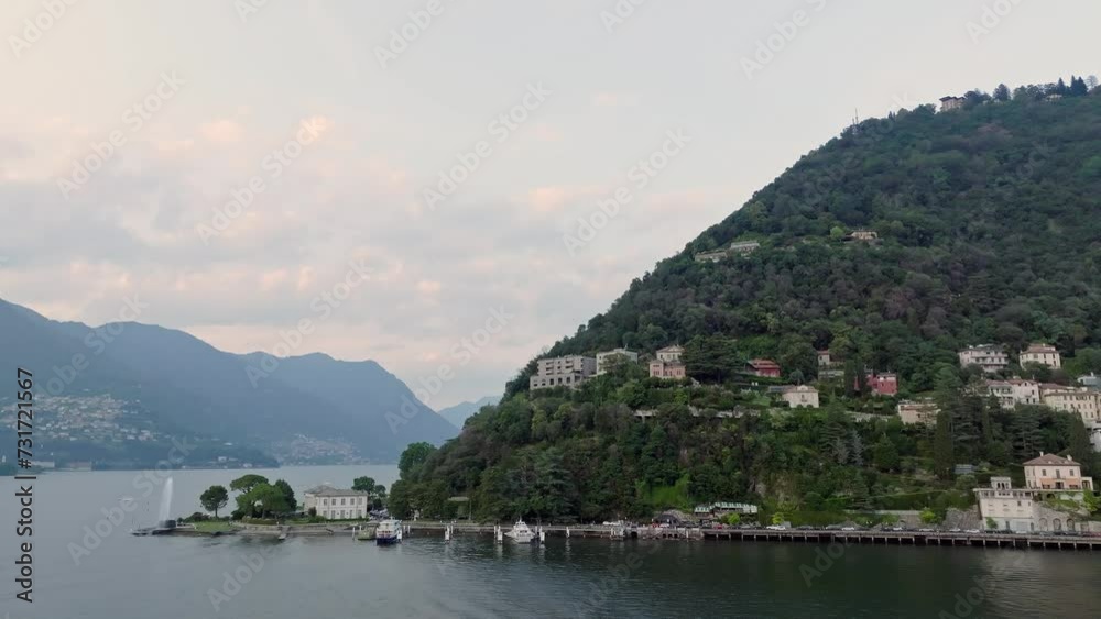 Drone shot over Como lake with view of Bellagio town and forested hill Drone shot over Como lake with view of Bellagio town and forested hill