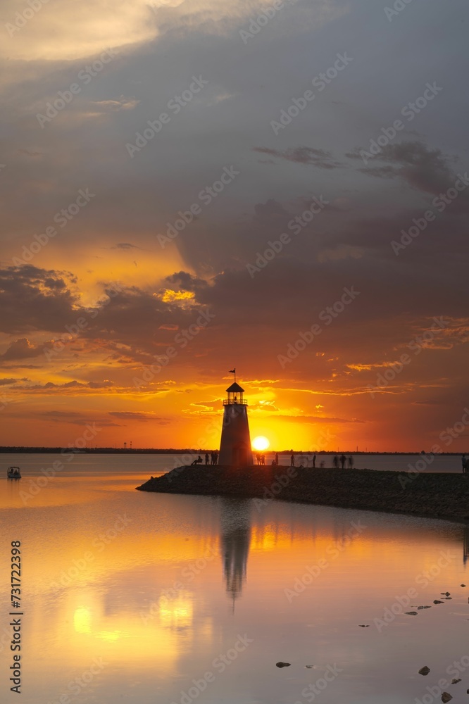 Vertical shot of a lighthouse with a stunning sunset sky, filled with clouds in the background