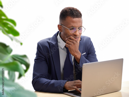 African-American business man on his laptop analyzing data. Black man showing signs of stress, or worried about work or job. Male in a corporate environment on his computer. 