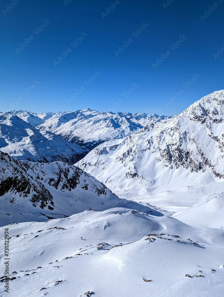 Picturesque landscape of majestic snowy mountain peaks with a beautiful blue sky background