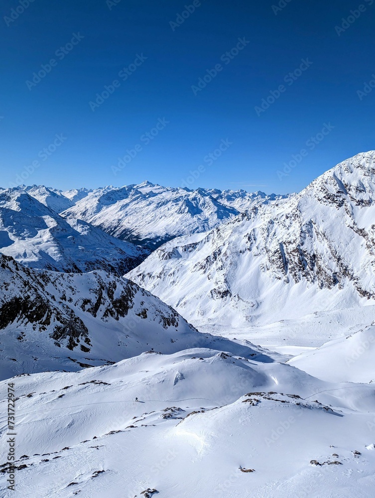 Picturesque landscape of majestic snowy mountain peaks with a beautiful blue sky background Picturesque landscape of majestic snowy mountain peaks with a beautiful blue sky background