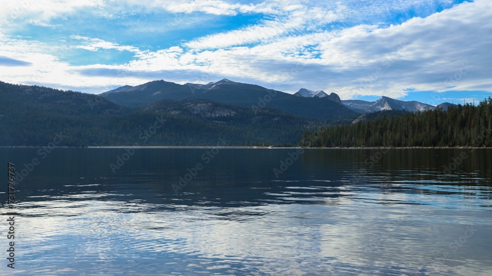 Scenic view of a tranquil lake surrounded by green pine trees and mountains