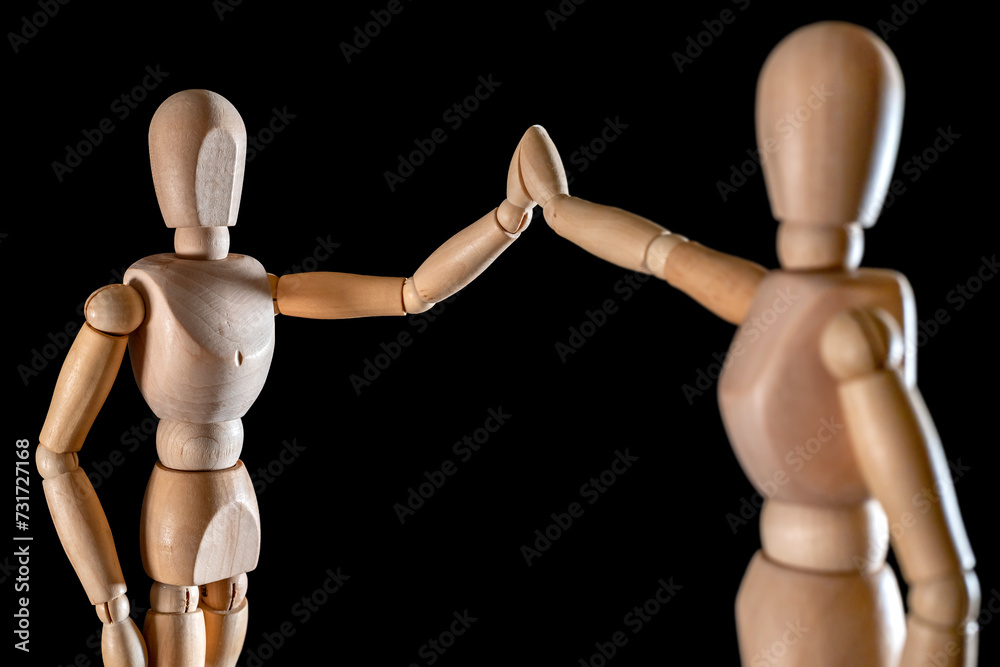 Zwei Holzfiguren geben sich High Five als Symbol für Erfolg Zwei Holzfiguren geben sich High Five als Symbol für Erfolg