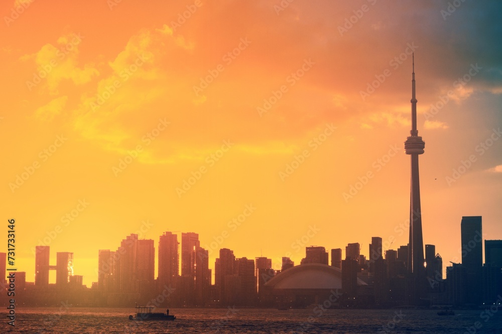 Skyline of Toronto at sunset with silhouettes of buildings against the orange sky. Canada.