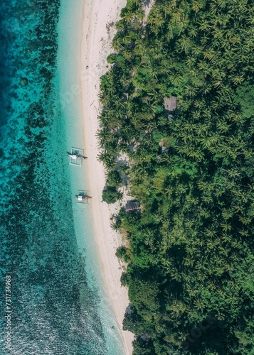 Aerial view of a tropical island surrounded by crystal clear, azure blue waters