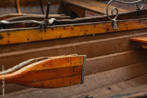Closeup of a paddle attached to the wooden rowing boat