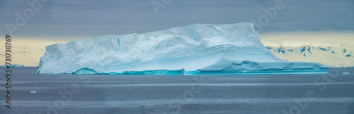 Flat top iceberg seperated from an ice shelf with caves, Paradise Bay, Gerlach Straight, Antarctica photo