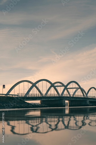 Picturesque arched bridge spanning a tranquil body of water at sunset