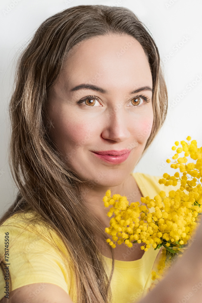 Beautiful young woman with mimosa flowers on white background Beautiful young woman with mimosa flowers on white background