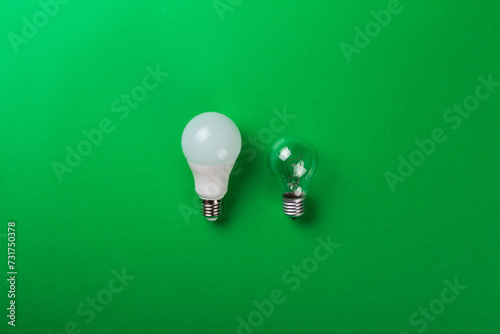 incandescent lamp and led lamps against on isolated green background. Energy efficiency concept. Flat lay. Concept ecology, save planet earth, idea, save energy, economy, saving. Earth day..