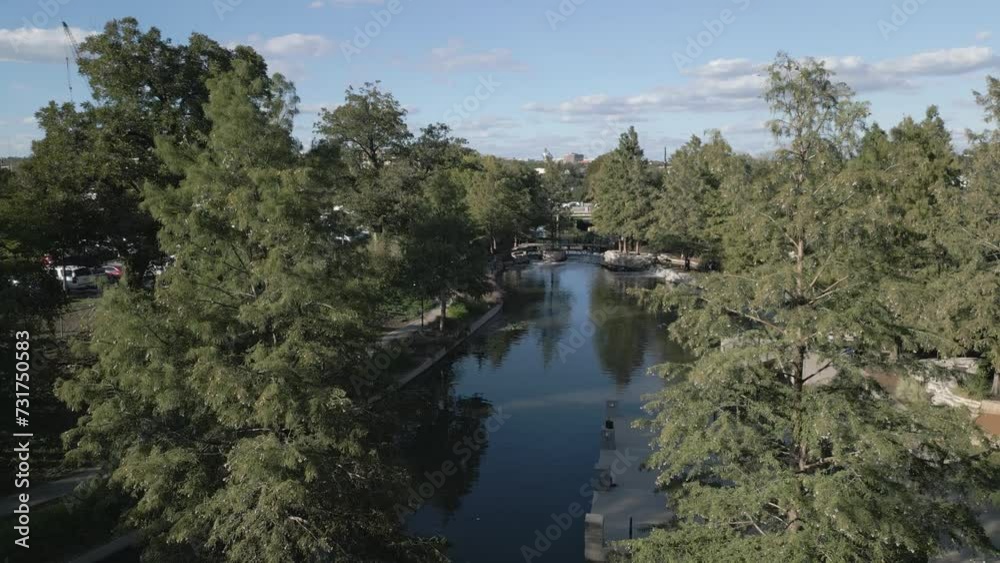 Drone shot over a reflecting lake with trees under cloudy sky on the horizon Drone shot over a reflecting lake with trees under cloudy sky on the horizon
