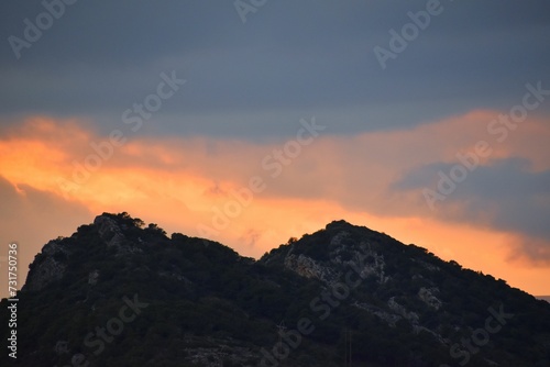 Beautiful sunset sky over the mountains covered in lush vegetation.
