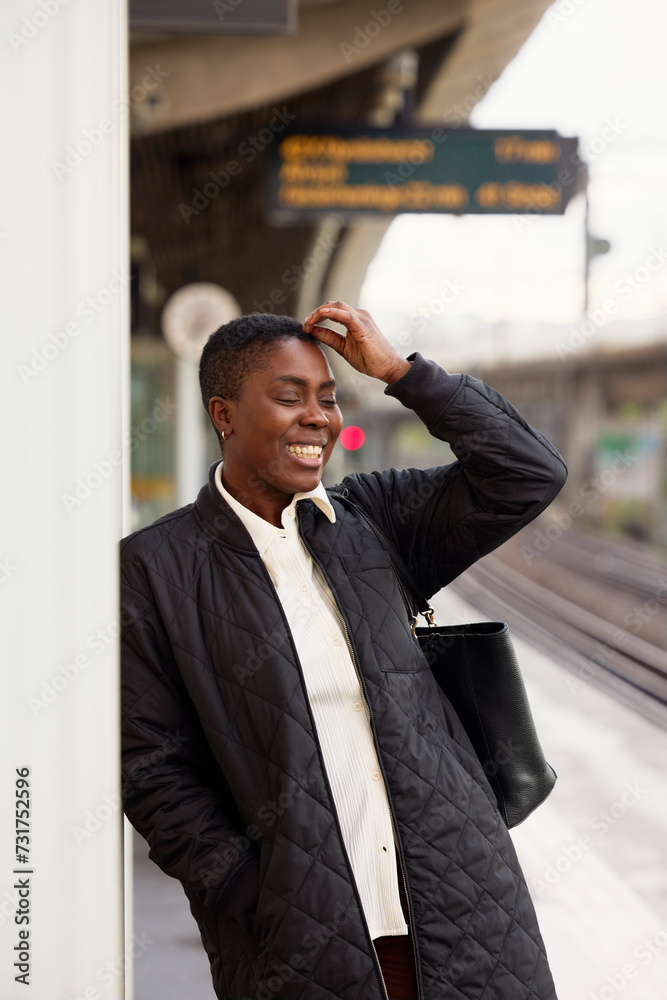 Happy businesswoman with hand in hair standing on platform Happy businesswoman with hand in hair standing on platform