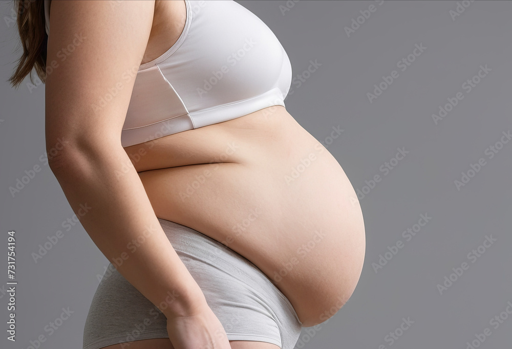 Side view of woman with protruding belly over white background - obrazy, fototapety, plakaty 