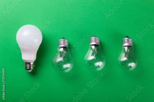 incandescent lamp and led lamp against on isolated green background. Energy efficiency concept. Flat lay. Concept ecology, save planet earth, idea, save energy, economy, saving. Earth day..