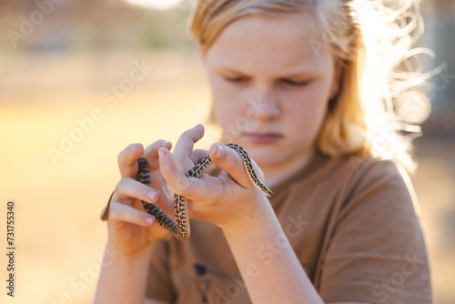 Pre-teen adolescent boy holding pet children's python snake photo