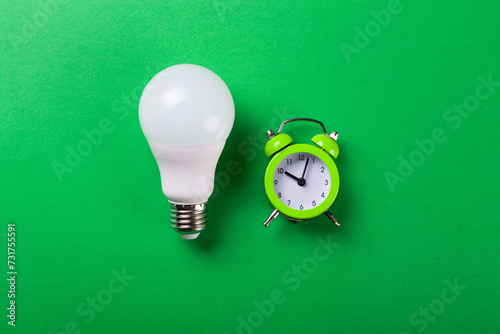 incandescent lamp and led lamps against on isolated green background. Energy efficiency concept. Flat lay. Concept ecology, save planet earth, idea, save energy, economy, saving. Earth day.. photo