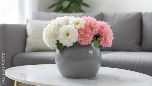 decorative grey vase with white and pink flowers in the middle of a couch