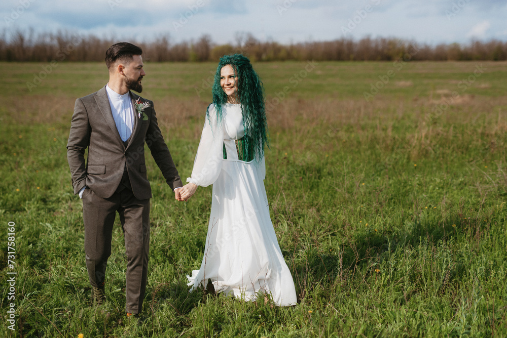 a bearded groom and a girl with green hair dance and twirl