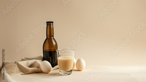 liquor in small glass and dark bottle on the light beige studio background, minimalism style