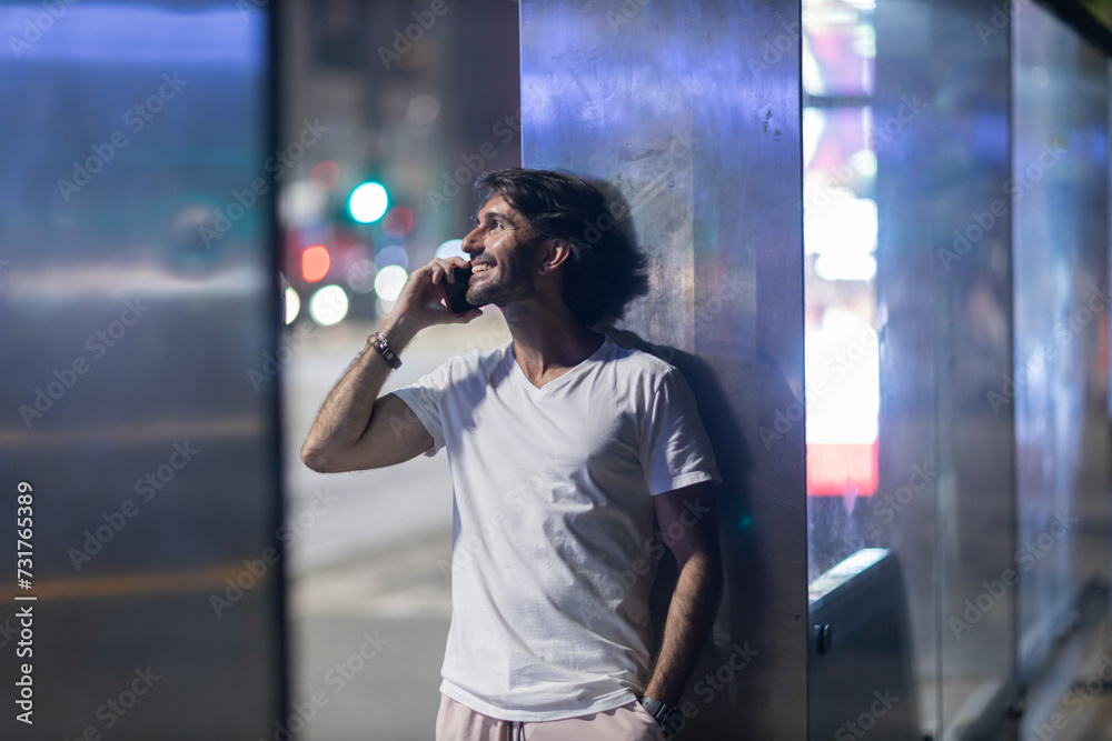 Fototapeta premium View of young man using a smartphone at night