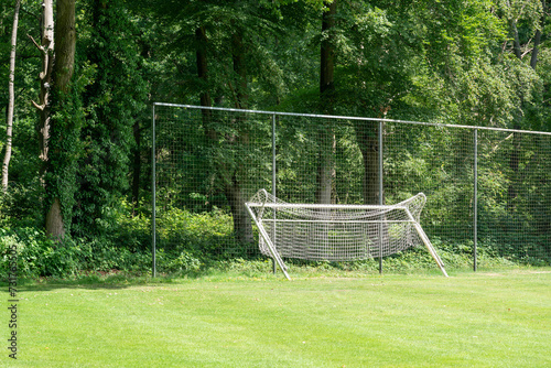 Goal posts resting to the protective fence of a soccer field in Loenen, The Netherlands.