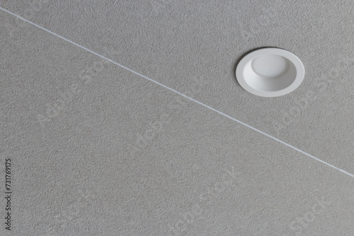 Modern minimal recessed electric white light fitting in textured grey interior ceiling photo