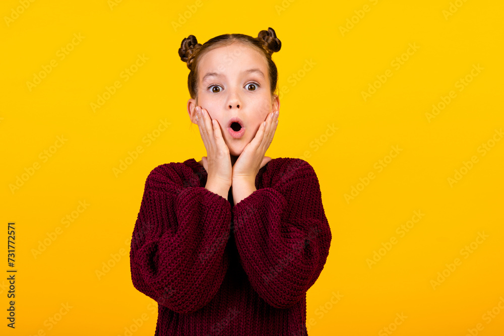 Photo of speechless schoolkid arms touch cheeks open mouth cant believe empty space isolated on yellow color background - obrazy, fototapety, plakaty 