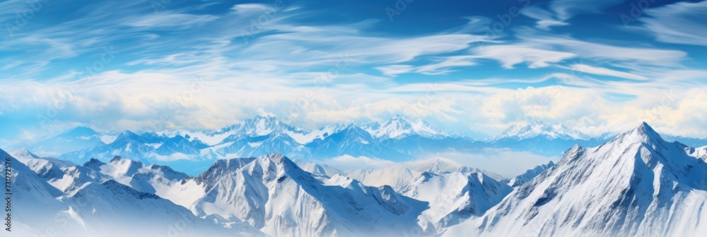 Landscape of a winter mountain range covered in snow with a bright blue sky.