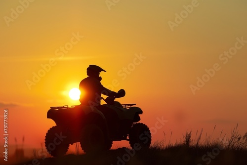 silhouette of an atv rider against a setting sun