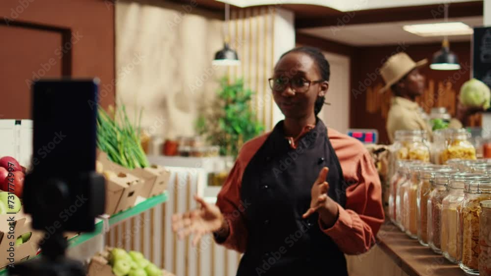 African american vendor presenting variety of pasta in jars, discussing about ethically sourced products and homemade food alternatives. Filming promotional video for healthy lifestyle. Camera B. African american vendor presenting variety of pasta in jars, discussing about ethically sourced products and homemade food alternatives. Filming promotional video for healthy lifestyle. Camera B.