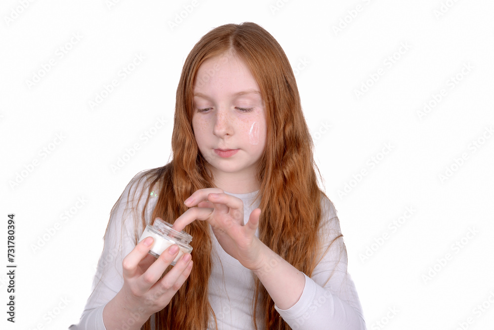 Redhead little girl with freckles uses face cream Redhead little girl with freckles uses face cream