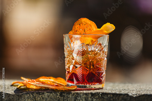 Delicious old fashion cocktail in the etched glass with ice and orange slices. Shallow dof.