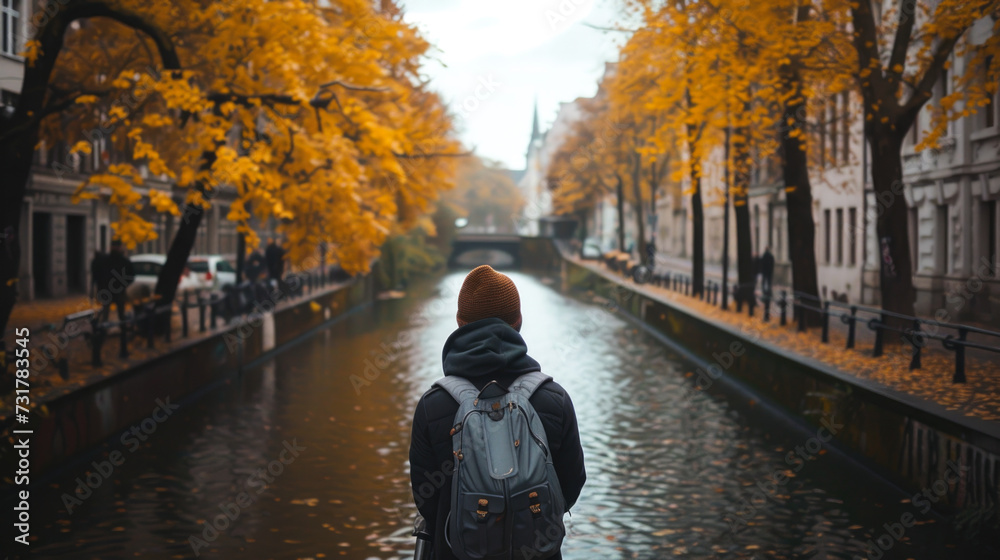 Autumnal Scene of a Person Contemplating a Canal in a European City Autumnal Scene of a Person Contemplating a Canal in a European City