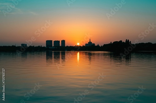the sunset reflects on the water in the distance with a cityscape visible