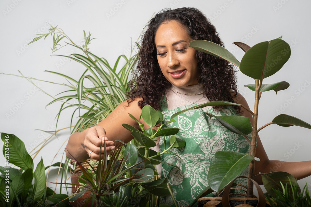 Studio portrait of smiling woman inspecting potted plant leaf Studio portrait of smiling woman inspecting potted plant leaf