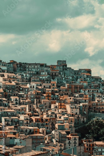 Scenic view of a residential area in Cammarata and cloud-filled sky in the background