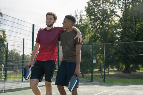 Smiling men in pickleball court