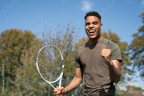 Smiling man with tennis racket © Cultura Creative