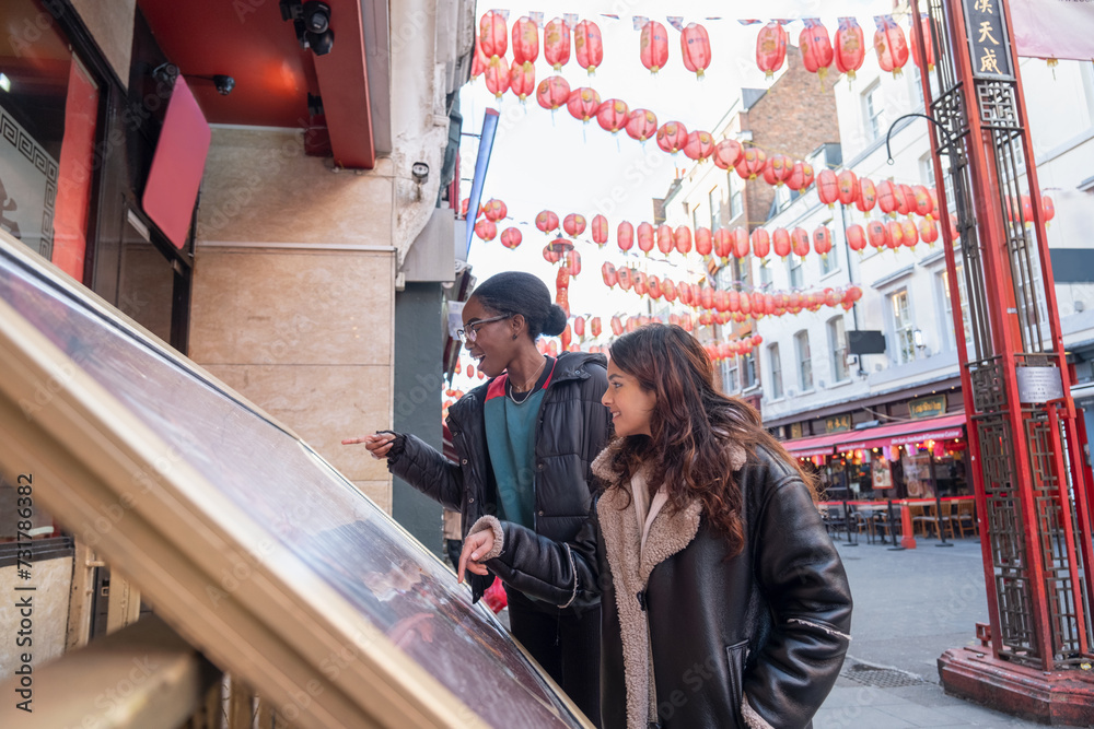 Two women checking menu at street restaurant in Chinatown